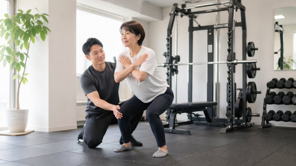 40〜50代の女性が、パーソナルジムでトレーナーと相談しながら自分に合う進め方を確認している様子